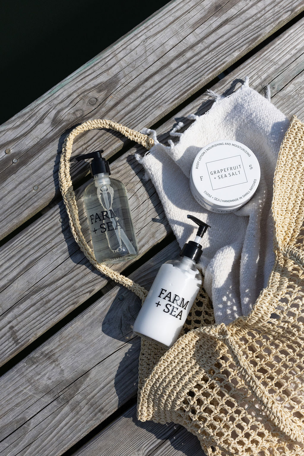 Farm + Sea bath and boy products on a wooden surface with a woven bag
