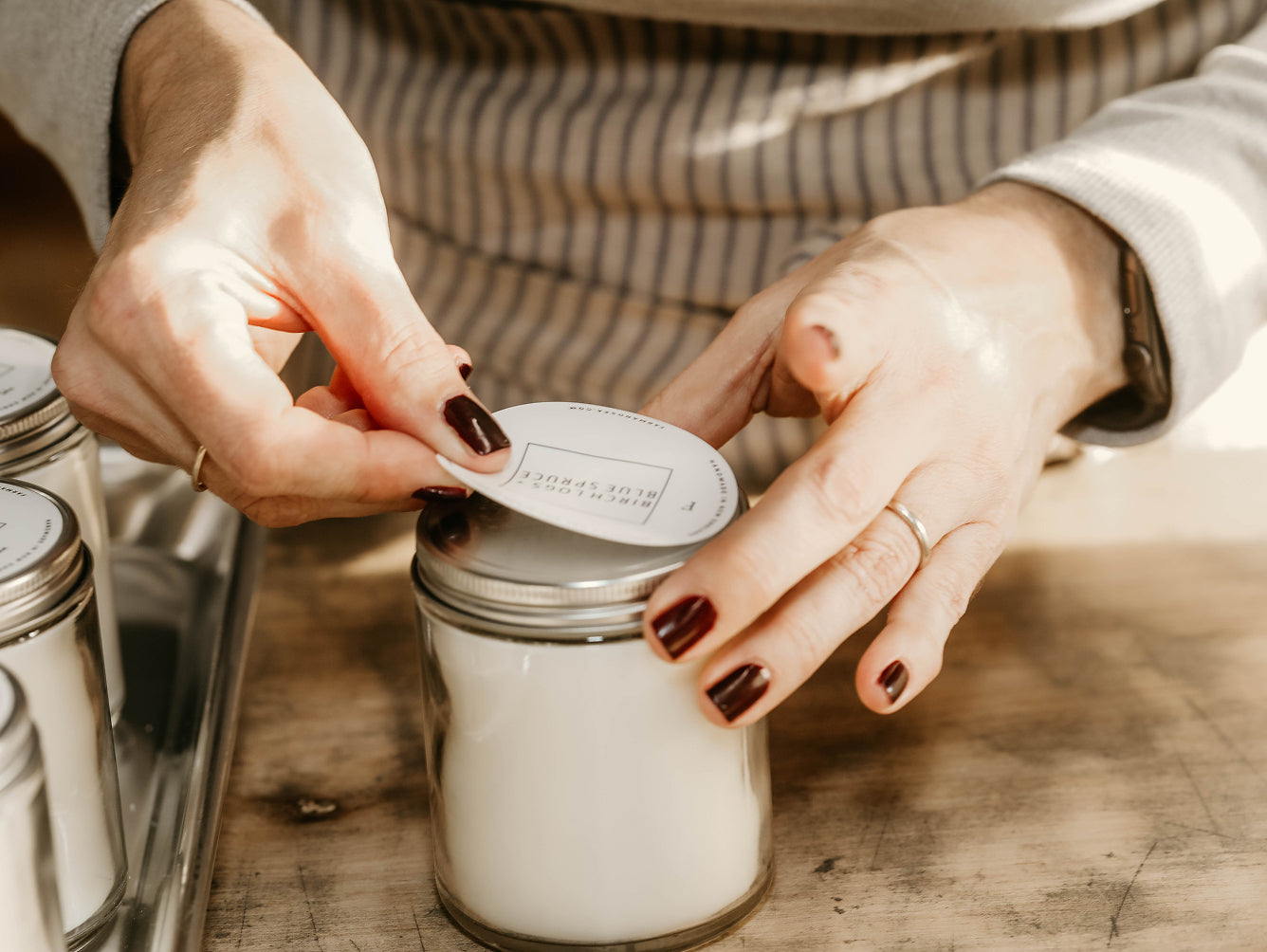 Mary, Farm + Sea founder, hand-labeling a classic candle